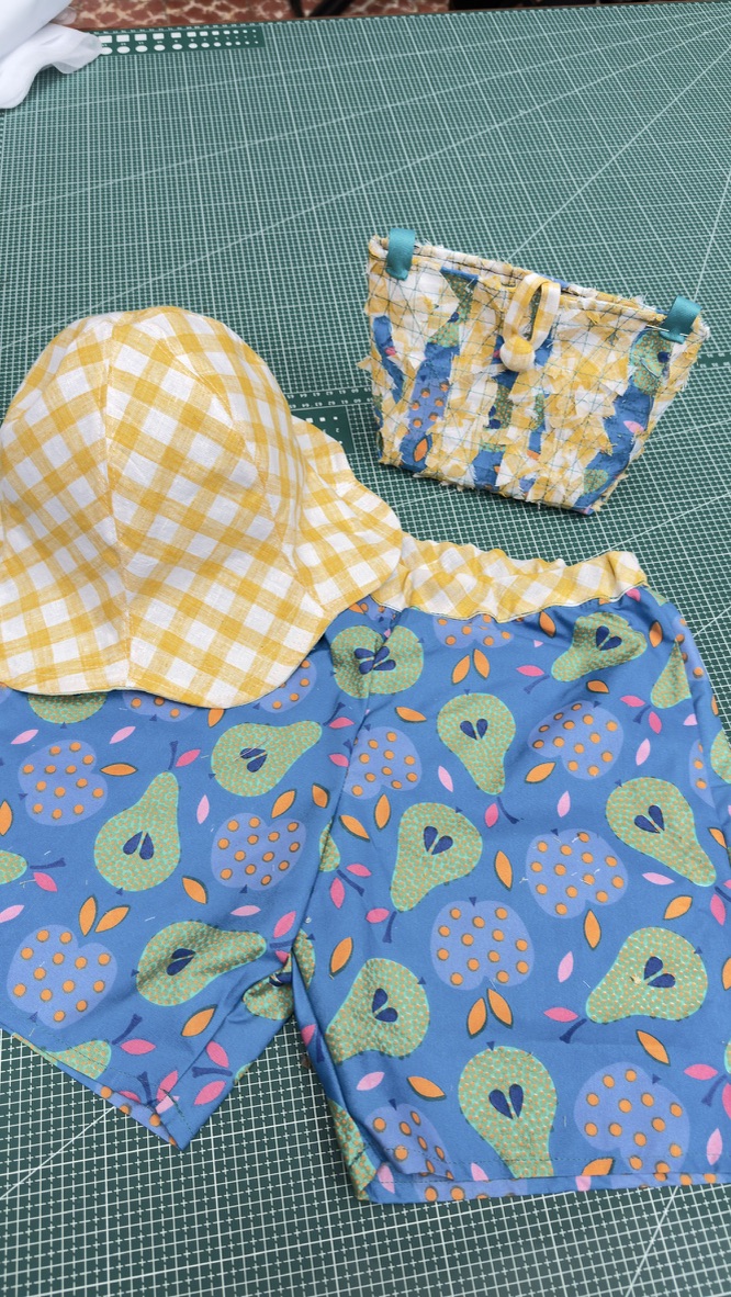 Piezas terminadas del taller de Ámate: sombrero, short y bolsita hechos a mano